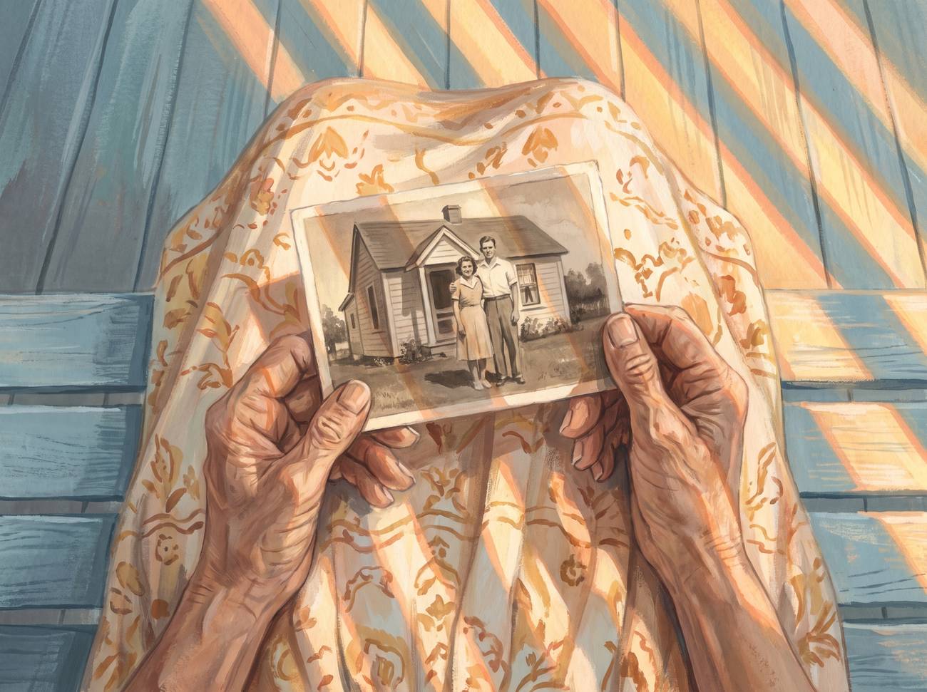 An older person's hands holding a faded photograph of a young couple in front of a small house, in warm evening light.